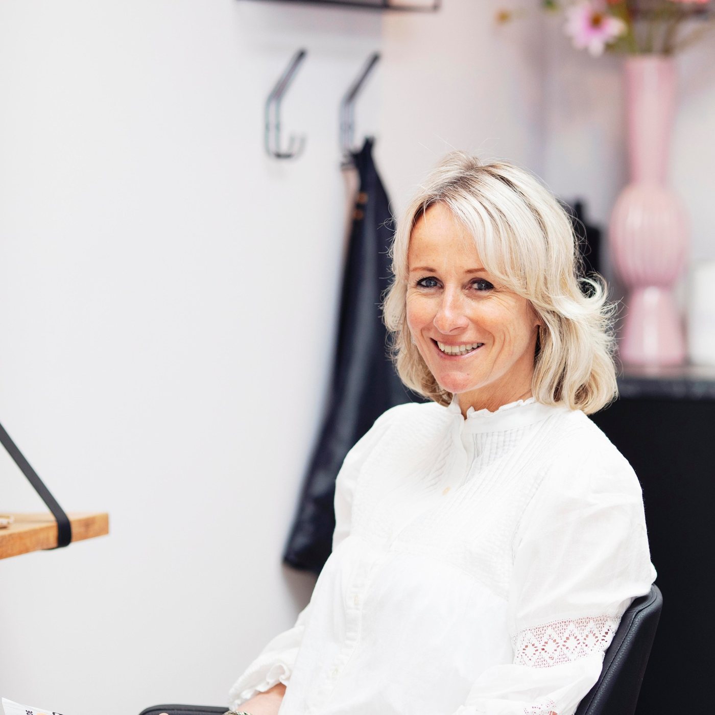 Evelien lachend in een kappersstoel in haar salon